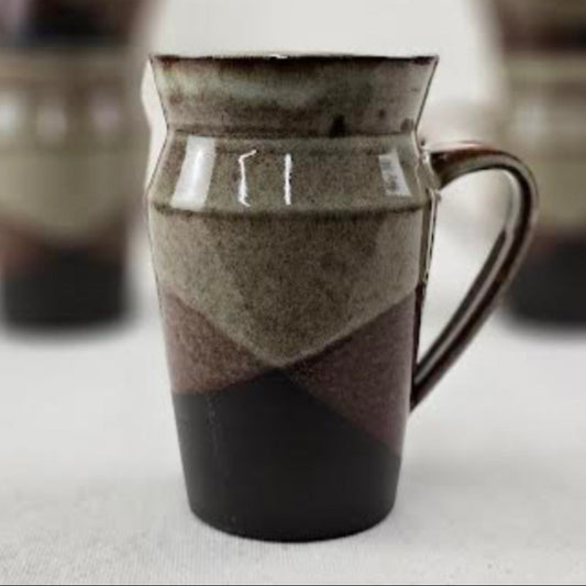 Ceramic pitcher with a layered design on a light background
