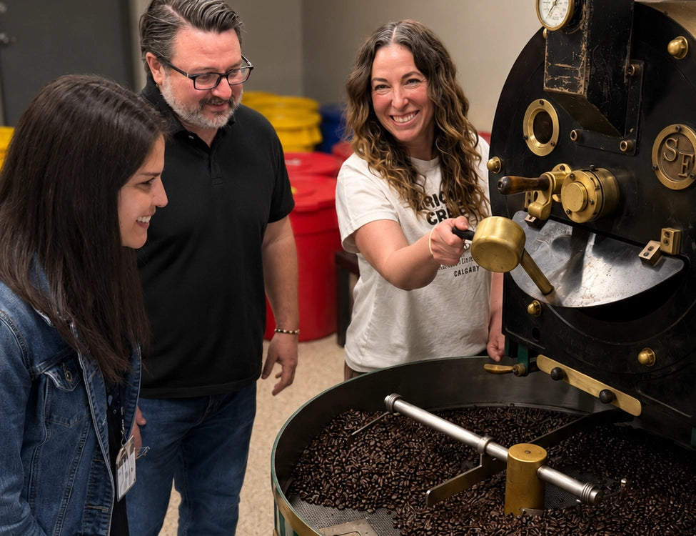 People observing a coffee roasting process with a large roaster machine at Crickle Creek Coffee Roasters in Calgary, Canada